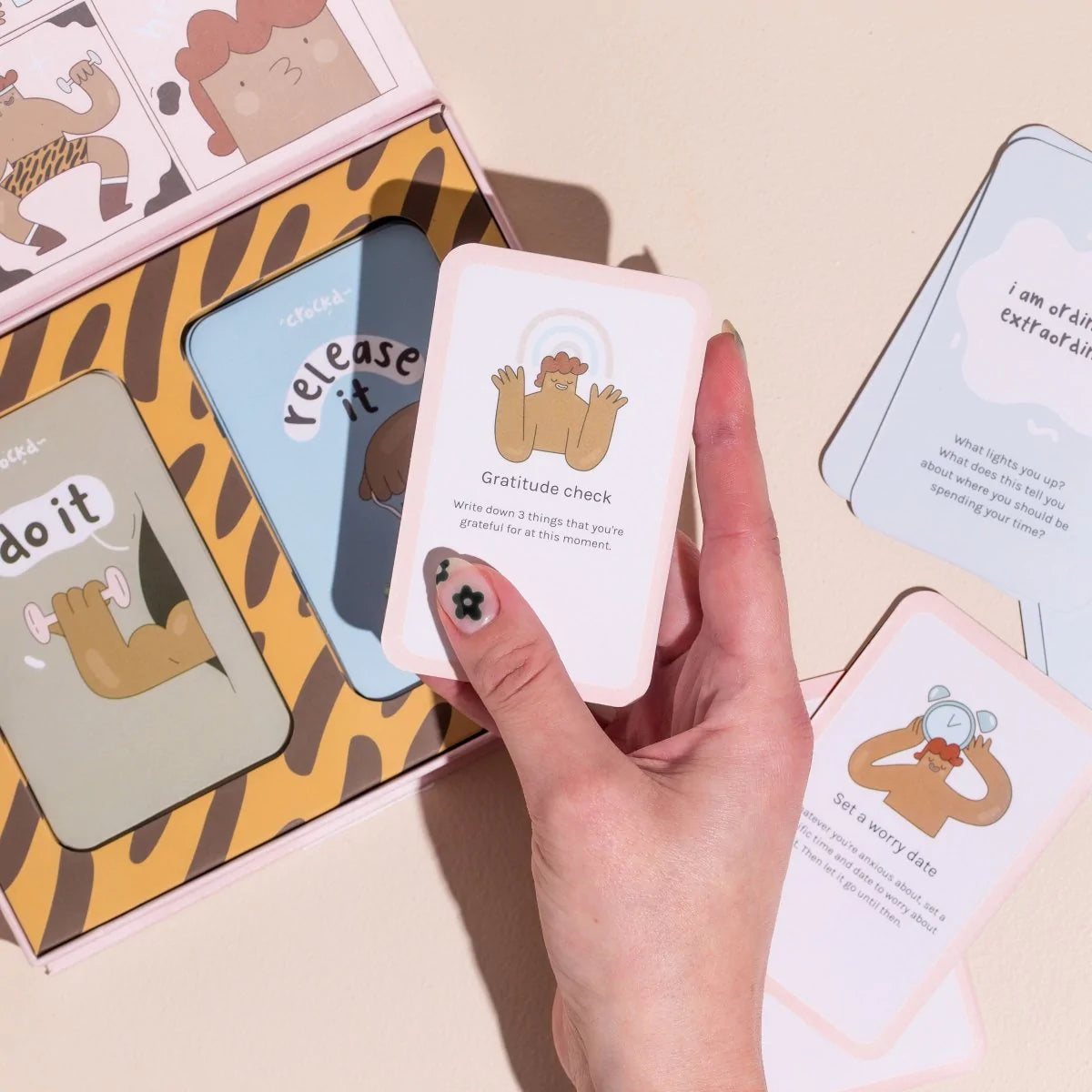 Hand picking up a do it creative mindfulness card for gratitude