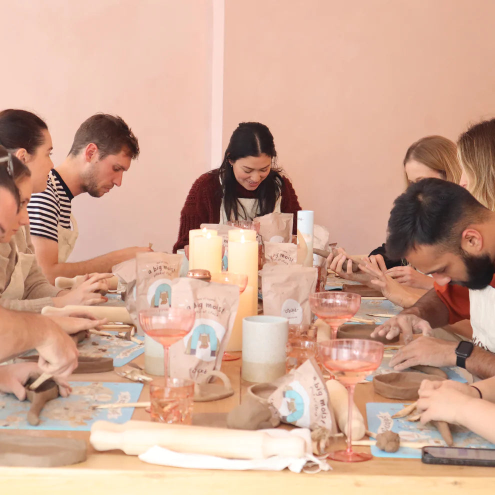 A table of friends enjoying the creation process of getting messy with clay at Crockd Studios